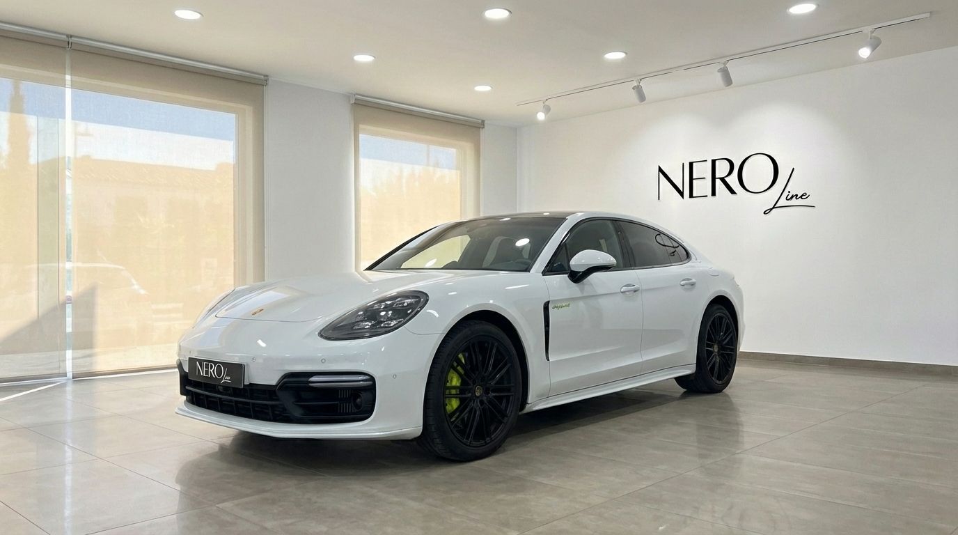 The white Porsche Panamera Turbo S Hybrid is parked in a showroom in Alicante, showing its front three-quarter view.