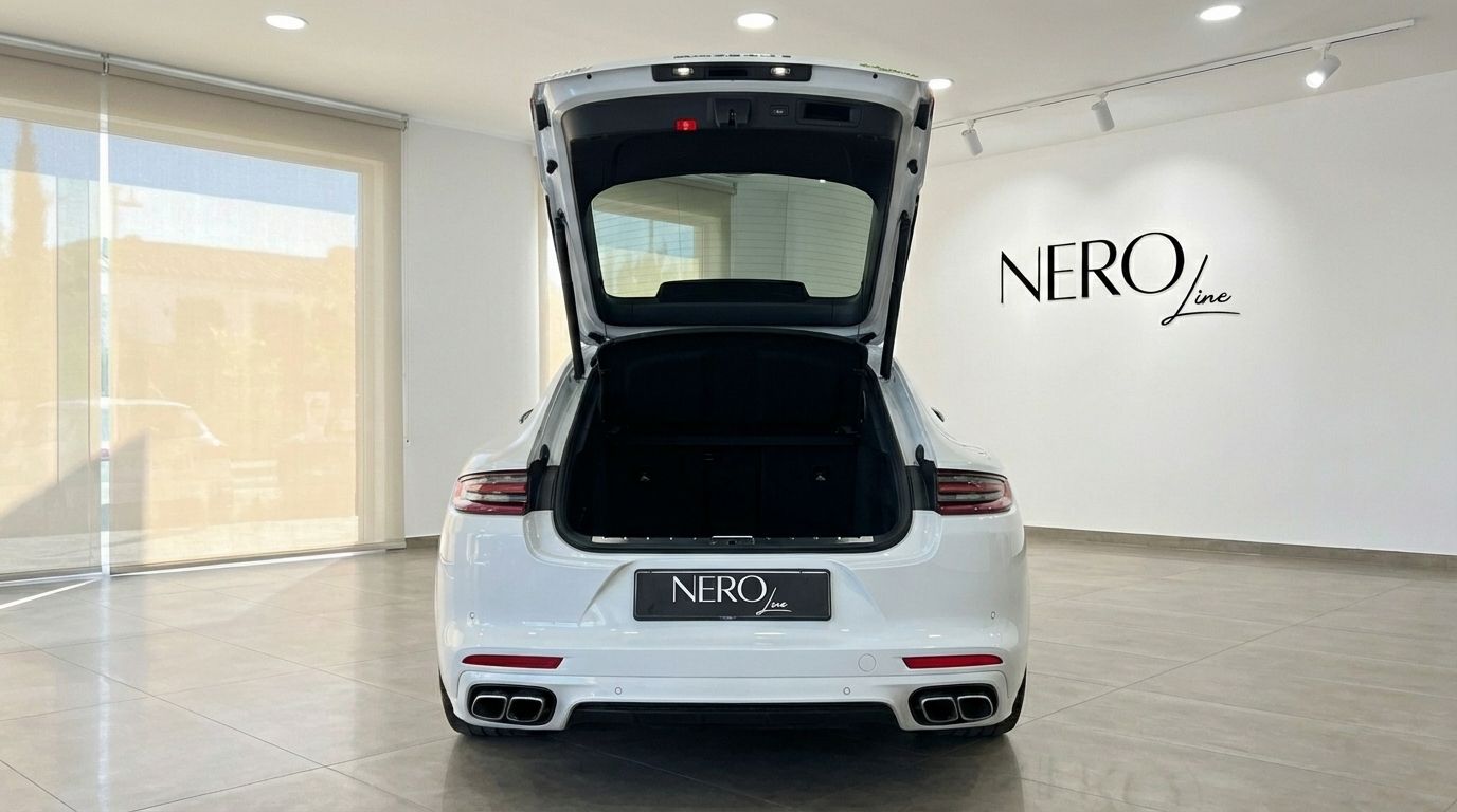 White Porsche Panamera Turbo S Hybrid from the rear with its trunk open, showcasing its spacious cargo area in Alicante.