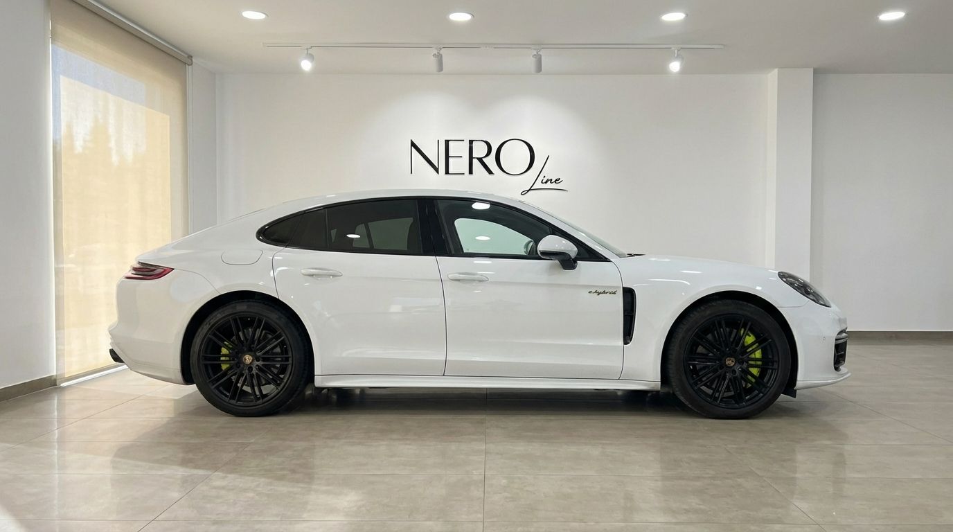 White Porsche Panamera Turbo S Hybrid luxury sedan shown in a clean side profile view, parked indoors in Alicante.