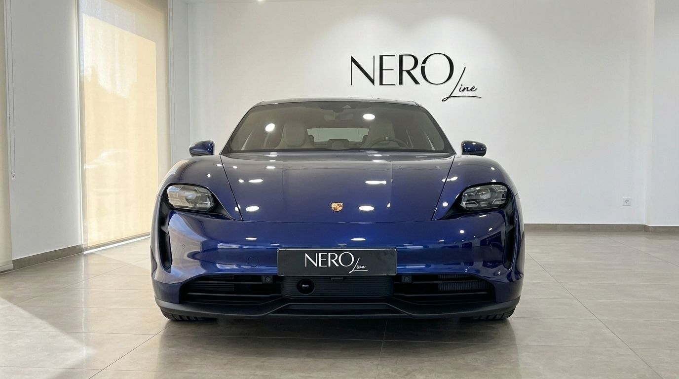 The front view of a blue 2022 Porsche Taycan 4S electric luxury sedan, parked indoors in Alicante.
