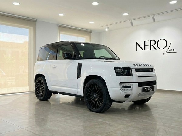 Range Rover Defender 90 Startech — Showroom view The white Range Rover Defender 90 Startech Edition is showcased from a front three-quarter angle in a modern showroom in Marbella.