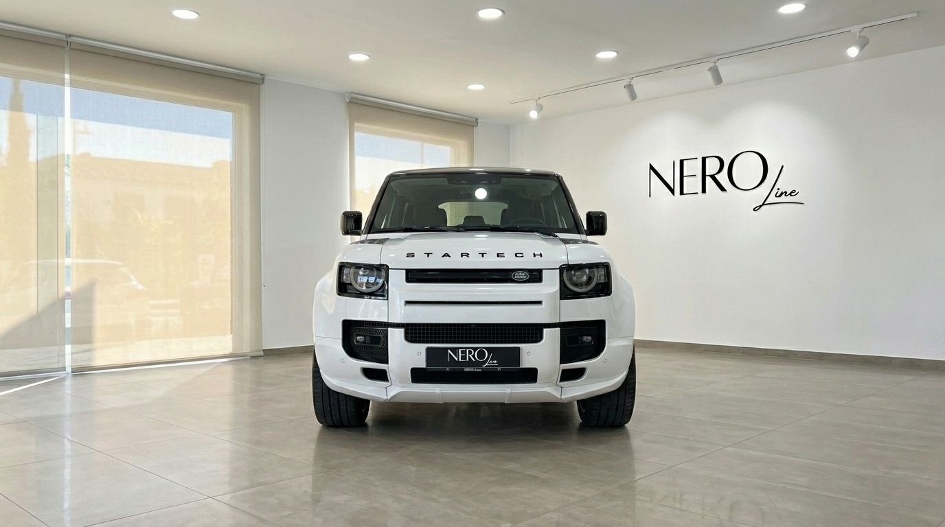 Der weiße Range Rover Defender 90 Startech Edition wird prominent von vorne in einem Showroom in Marbella präsentiert.
