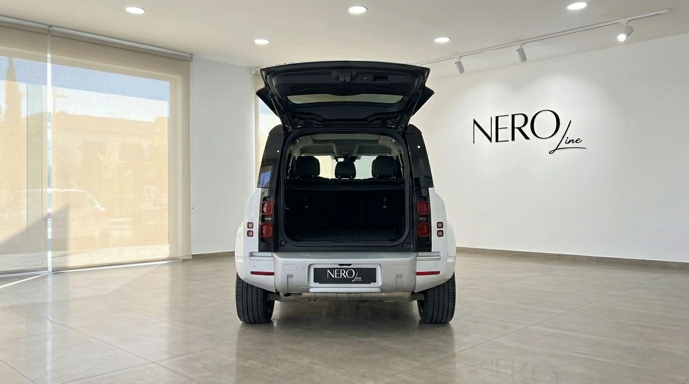Der weiße Range Rover Defender 90 Startech Edition, Heckansicht mit offenem Kofferraum, enthüllt seinen leeren Laderaum in einem Showroom in Marbella.