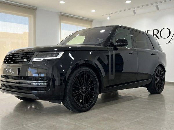 Range Rover LWB P530 Autobiography — Showroom Madrid El Range Rover LWB P530 Autobiography 2023 negro Santorini brillante se exhibe en vista frontal tres cuartos en un showroom de Madrid.