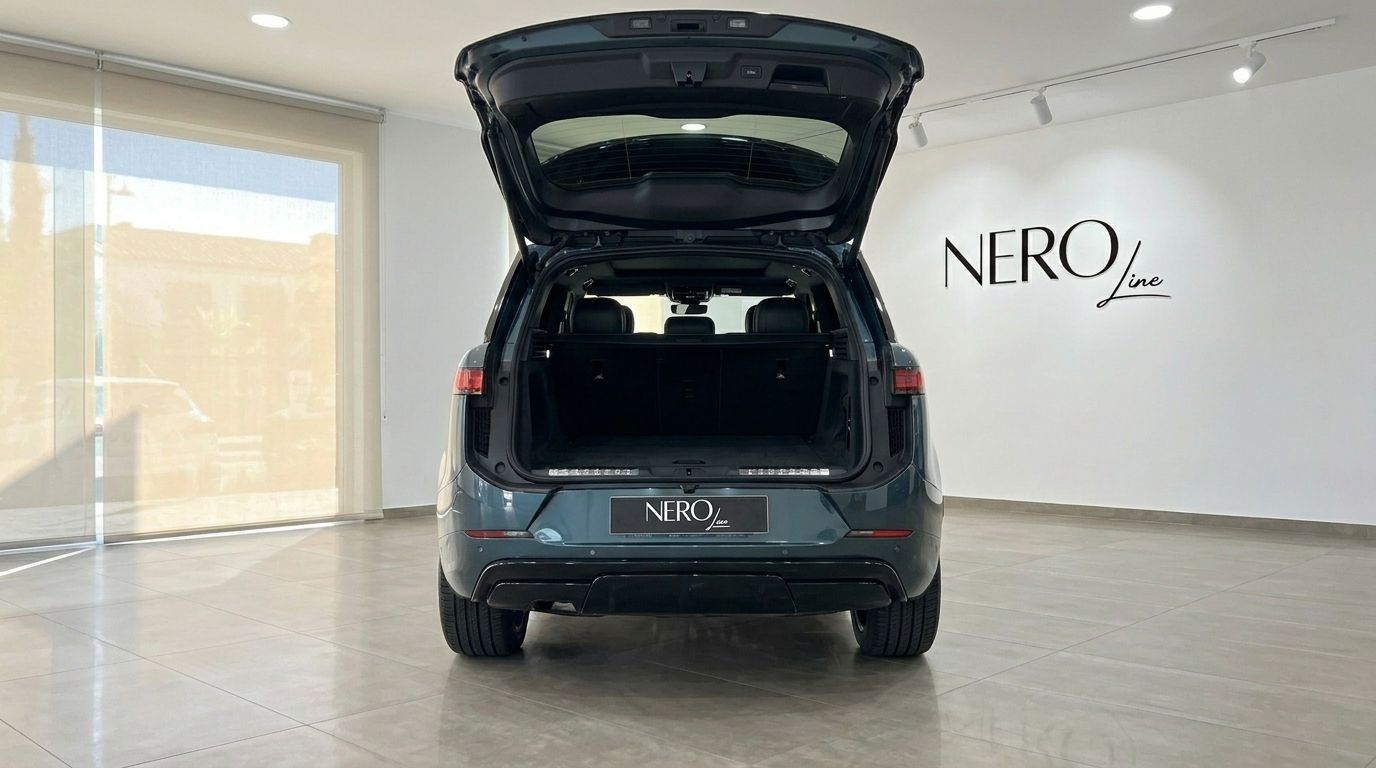 Vista trasera de un Range Rover Sport verde Giola metálico con el maletero abierto, aparcado en un luminoso showroom en Madrid.