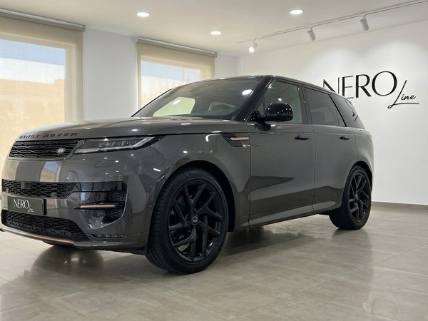 Range Rover Sport — Vista tres cuartos frontal Madrid El Range Rover Sport 2023 en gris oscuro metálico brillante se exhibe desde una vista tres cuartos frontal en un concesionario de Madrid.