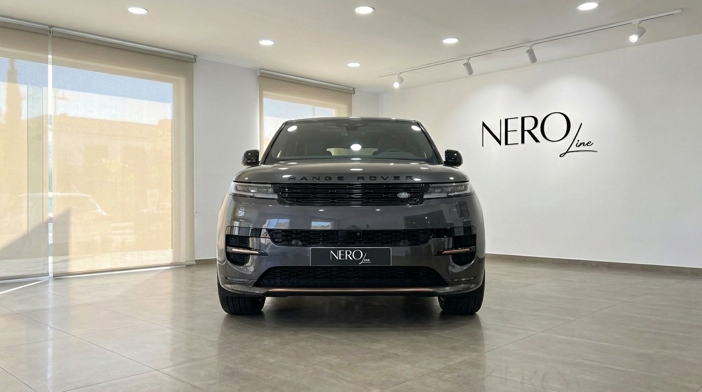 El Range Rover Sport 2023 gris oscuro metálico brillante se exhibe de frente en un luminoso showroom de Madrid.