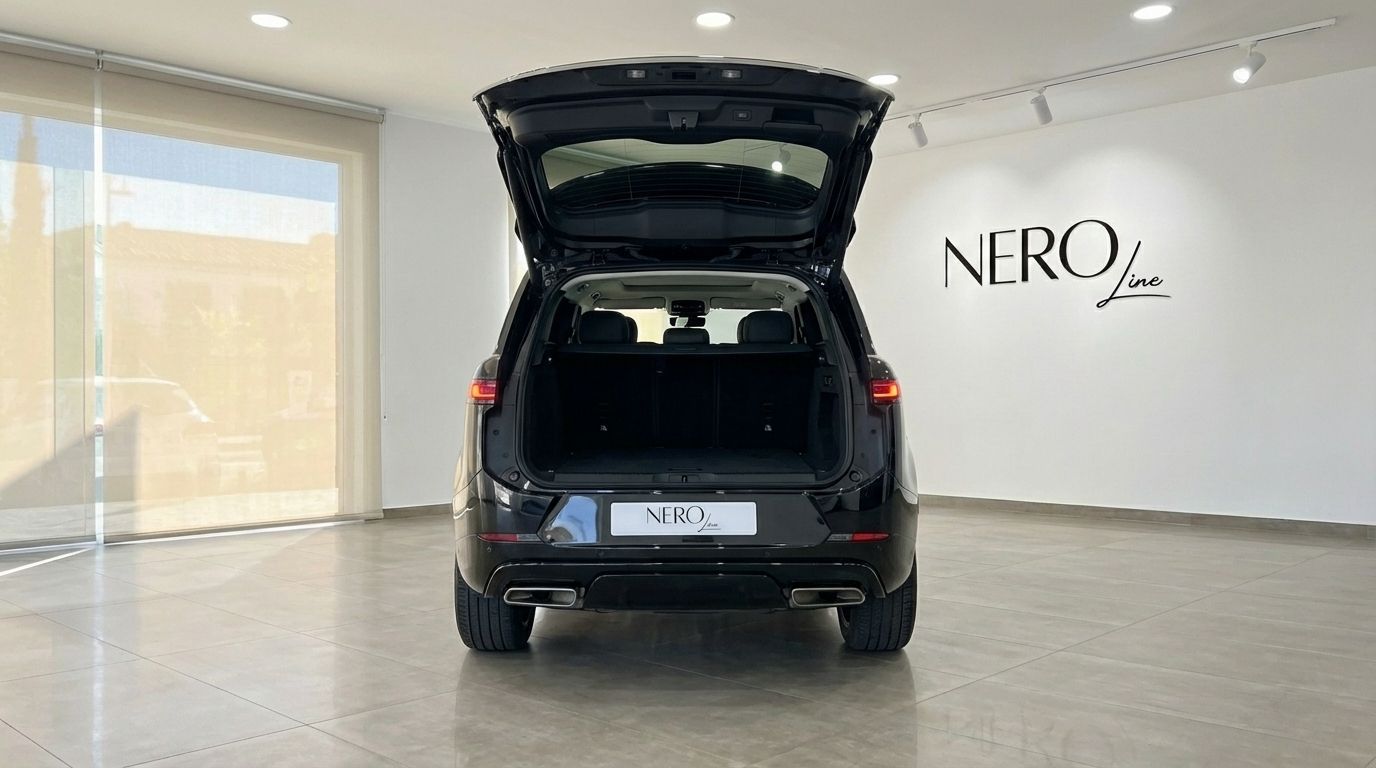 El Range Rover Sport 2024 negro azabache se muestra desde la parte trasera con el maletero abierto, aparcado en un concesionario en Madrid.