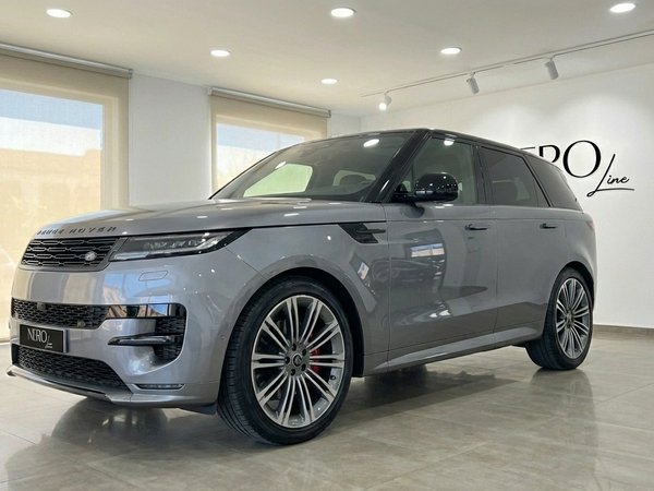 Range Rover Sport SE — Vista frontal tres cuartos El Range Rover Sport SE 2025 gris metalizado se exhibe desde un ángulo frontal tres cuartos en un concesionario de Madrid.