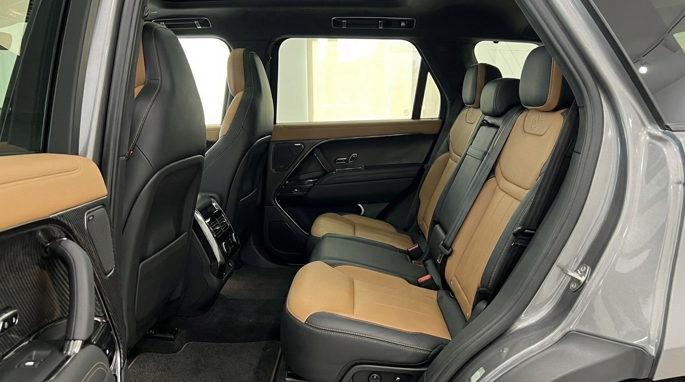 El lujoso interior trasero del Range Rover Sport SE 2025 en Madrid, con asientos de cuero bitono beige y negro y amplio espacio para las piernas.
