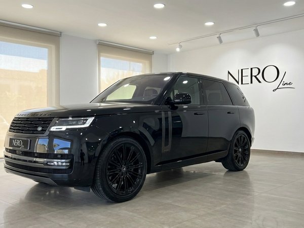 Range Rover Vogue Autobiography — Vista de showroom El Range Rover Vogue Autobiography 2023 negro brillante Santorini se exhibe desde un ángulo frontal-lateral en un concesionario de Madrid.