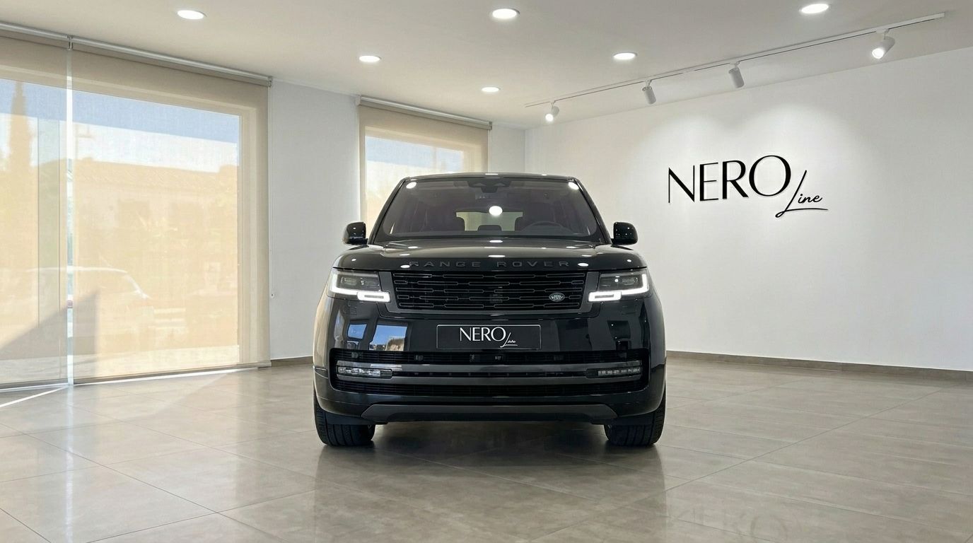 Un Range Rover Vogue Autobiography 2023 negro está aparcado de frente en un concesionario de Madrid, mostrando su imponente parrilla delantera.