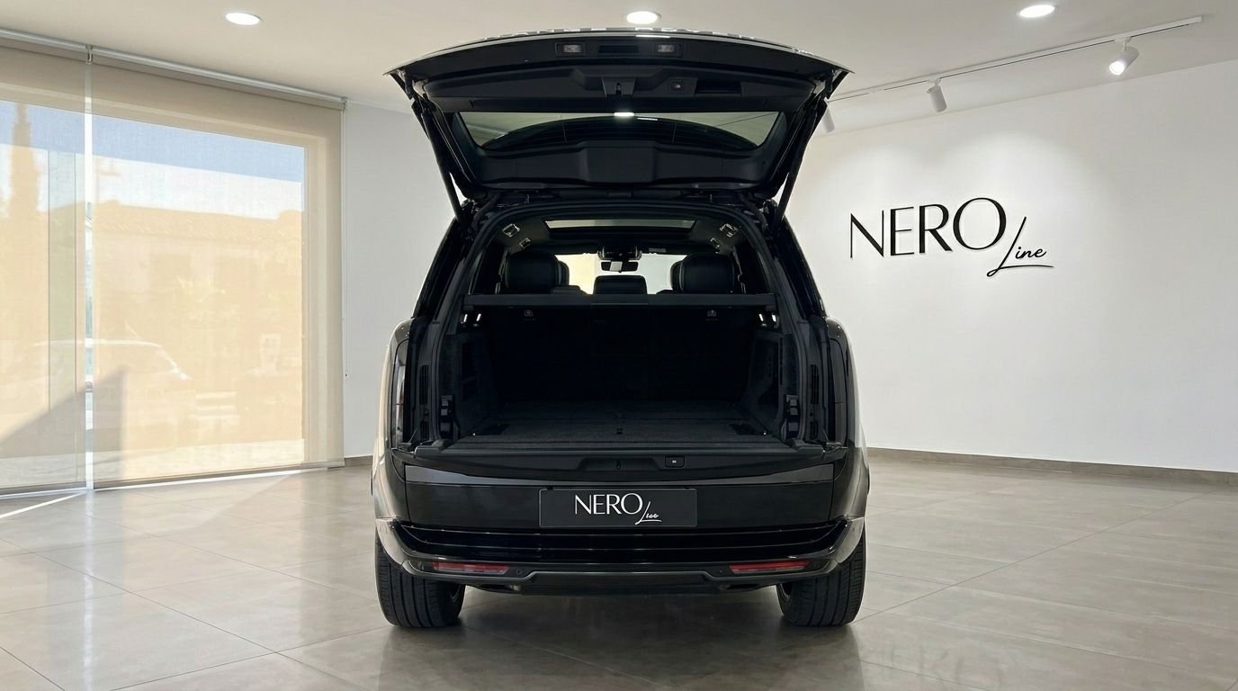 El Range Rover Vogue Autobiography negro se muestra desde la parte trasera con el maletero abierto, estacionado en un concesionario en Madrid.