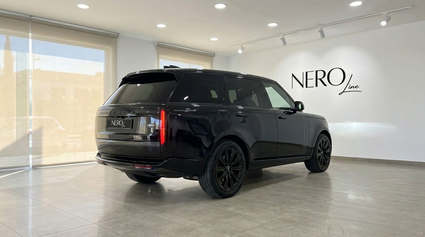 The black Range Rover Vogue LWB Autobiography is showcased from a rear three-quarter view in a Marbella showroom.