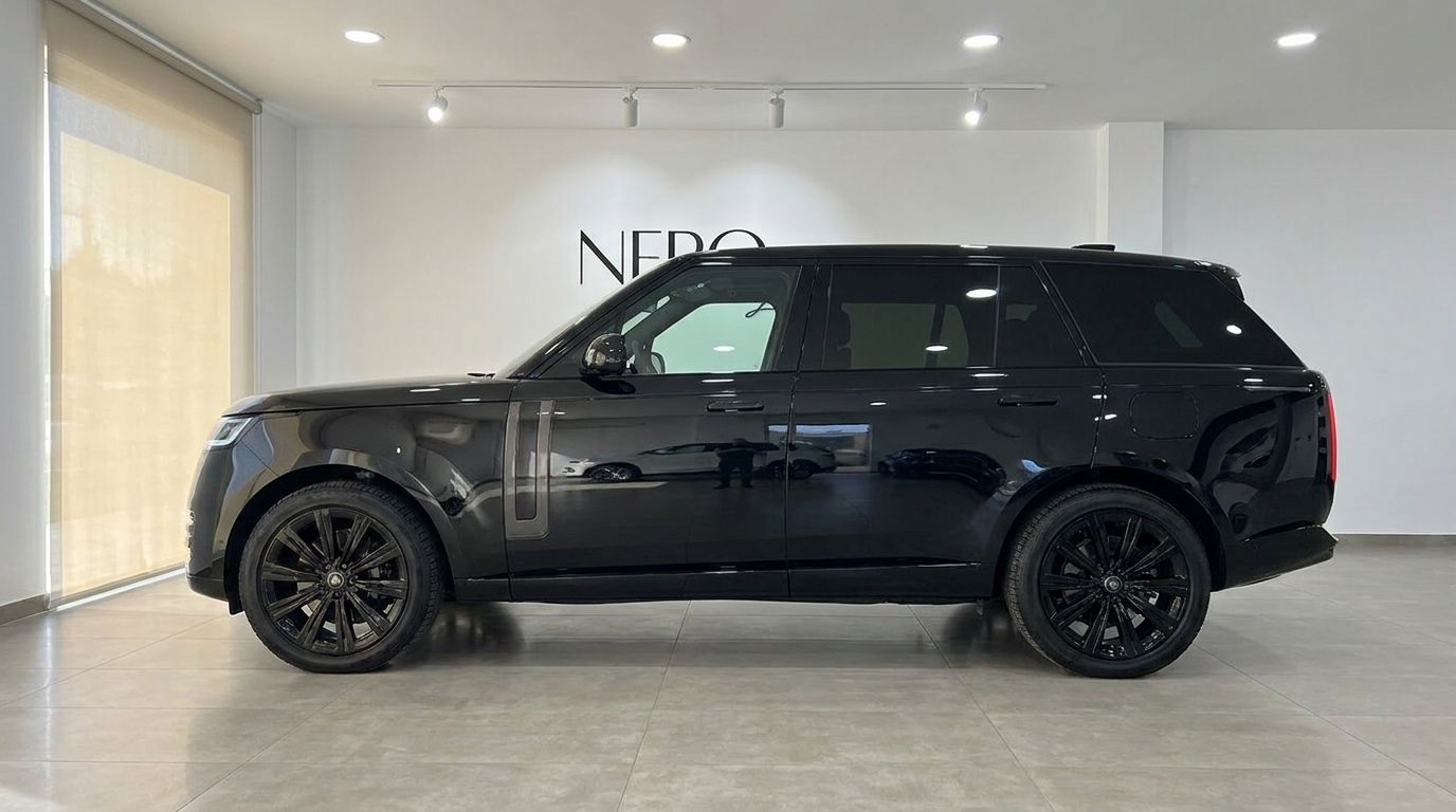 The gloss Santorini Black 2025 Range Rover Vogue LWB Autobiography is displayed in a full side profile view in a Marbella showroom.