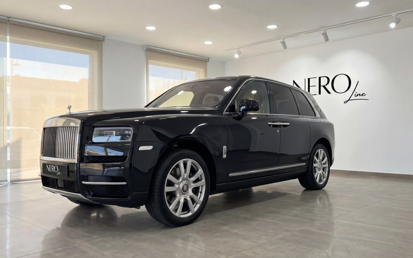 Rolls-Royce Cullinan — Luxury SUV in Ibiza A jet black 2024 Rolls-Royce Cullinan luxury SUV is parked in a showroom in Ibiza, shown from the front three-quarter angle.