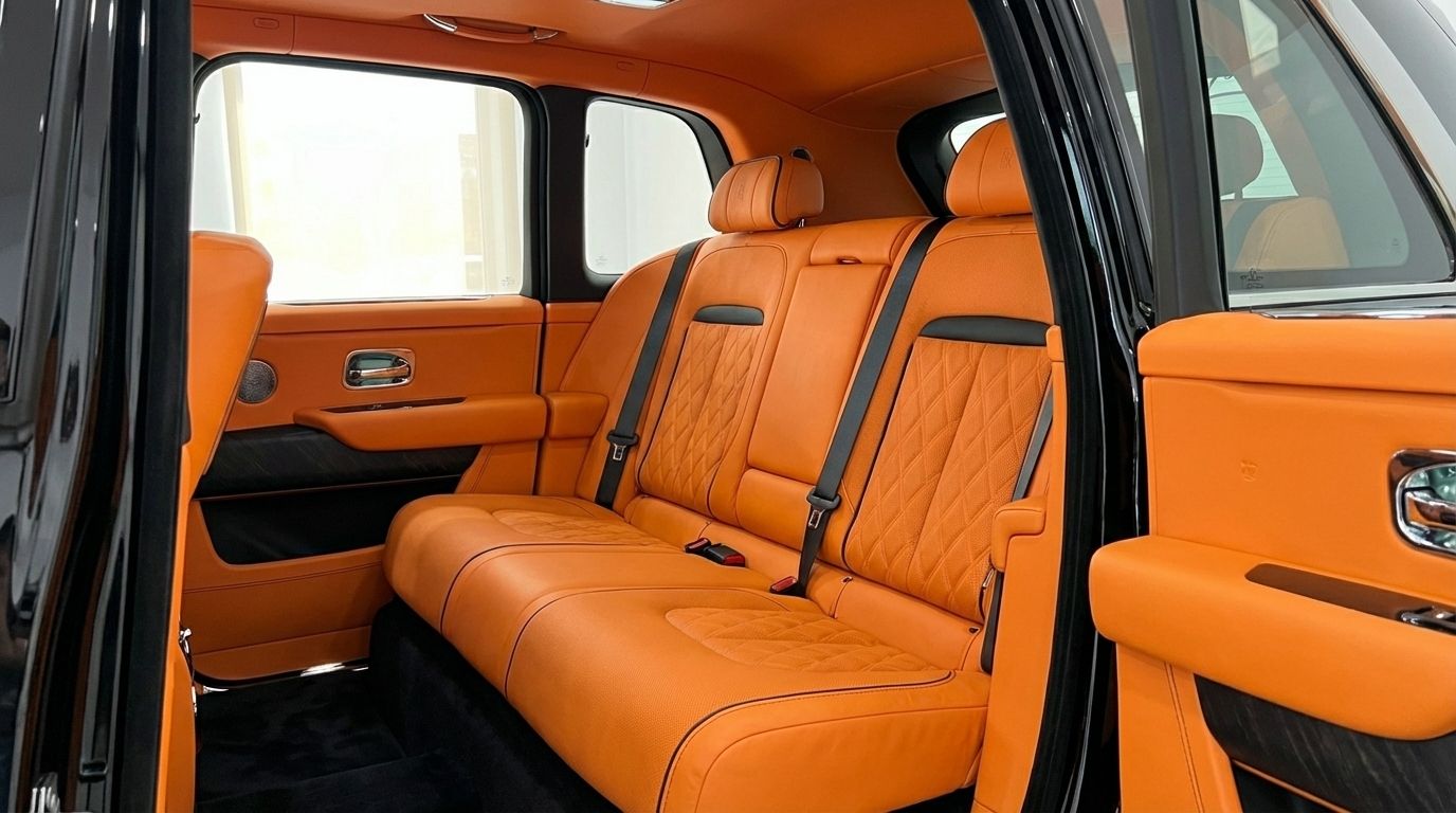Los lujosos asientos traseros y paneles de puerta de cuero naranja del Rolls-Royce Cullinan 2025 en Madrid.