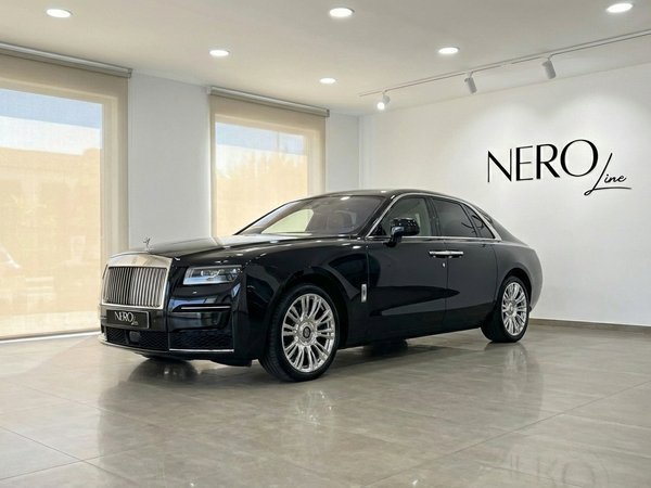 Rolls-Royce Ghost — Showroom Elegance Marbella The black 2025 Rolls-Royce Ghost is elegantly parked in a modern showroom in Marbella, showcasing its luxurious front three-quarter profile.