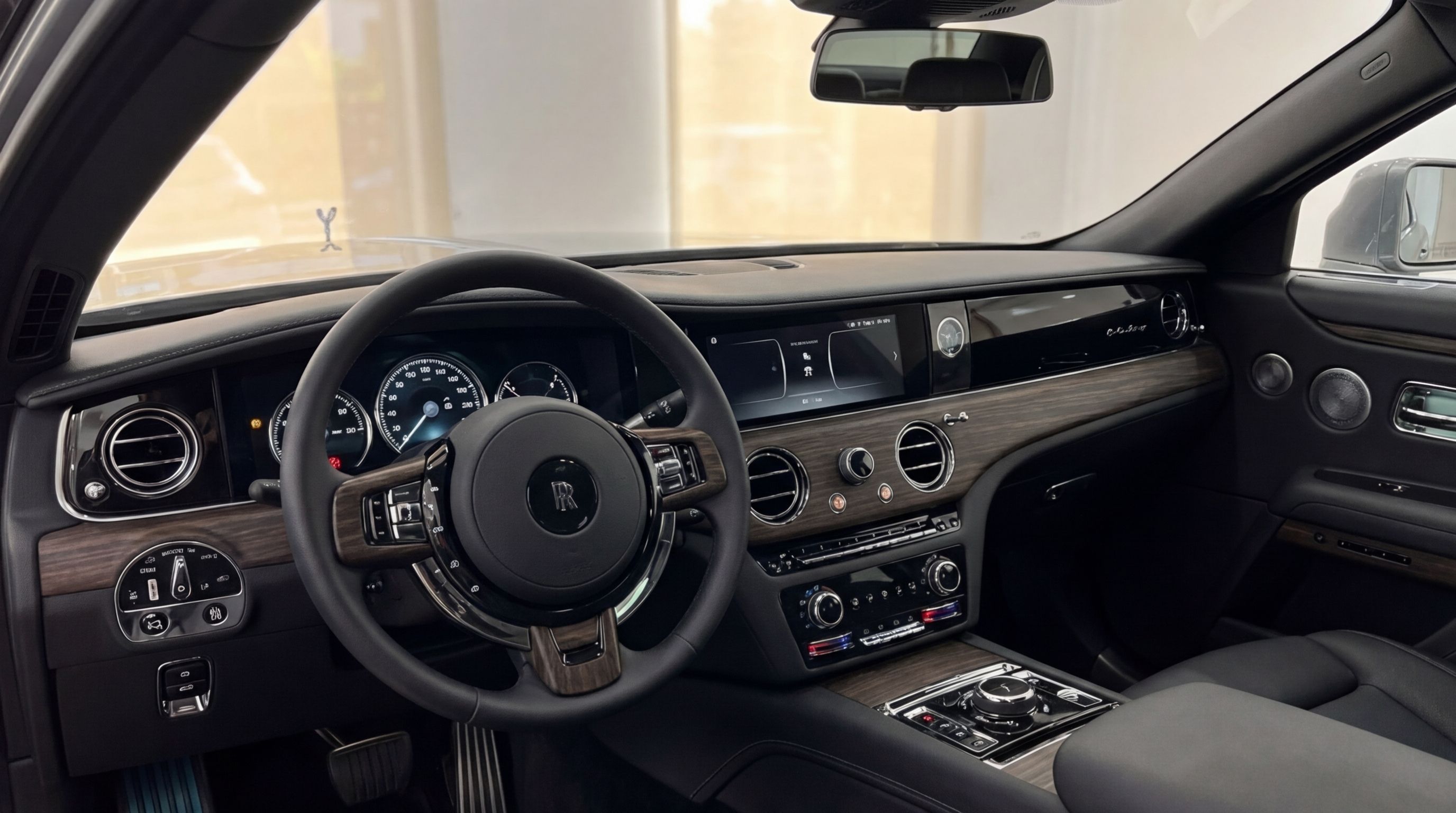 The opulent interior of the 2024 Rolls-Royce Ghost in Valencia, featuring its elegant steering wheel, wood-trimmed dashboard, and advanced infotainment system.