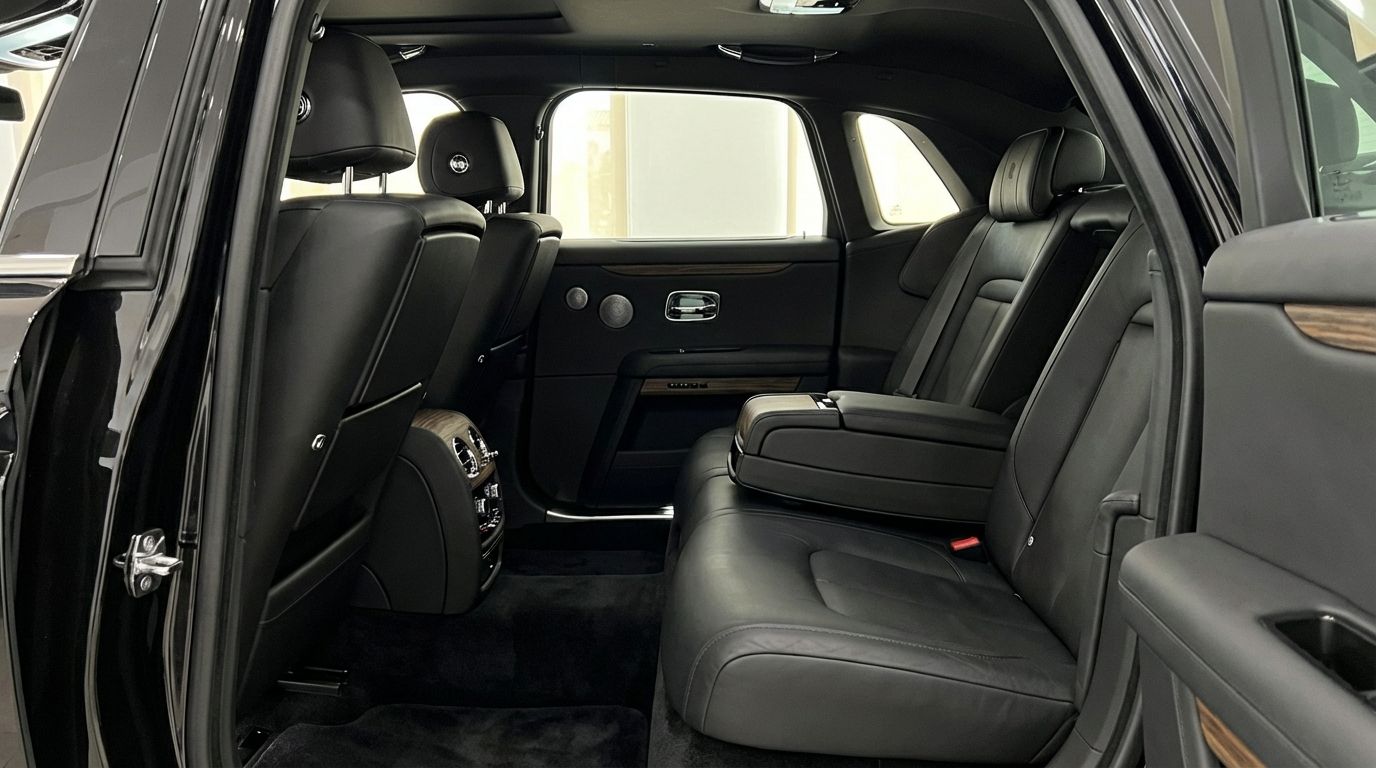 The luxurious black leather rear interior of the Rolls-Royce Ghost, showcasing comfortable seating and elegant wood trim in Marbella.