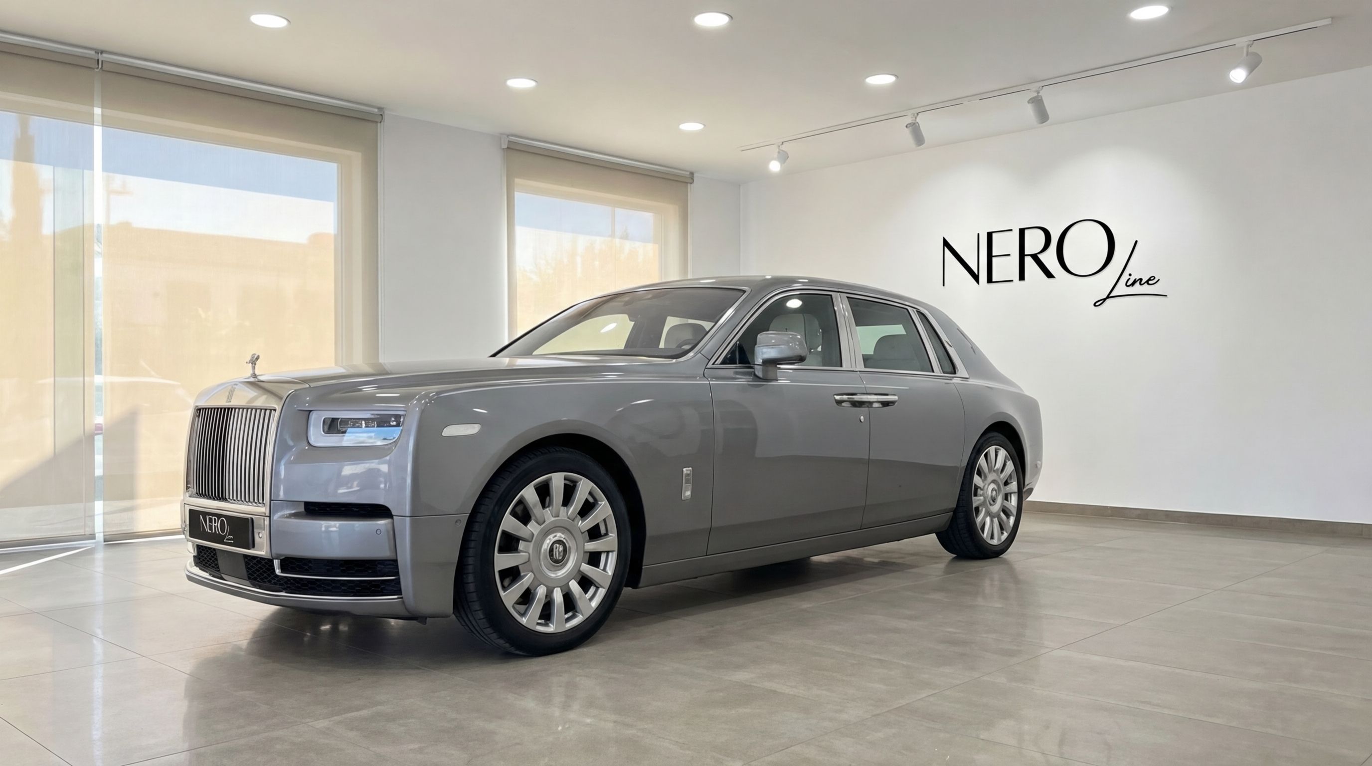 A metallic grey Rolls-Royce Phantom (2024) parked in a showroom in Mallorca, viewed from the front three-quarter angle.