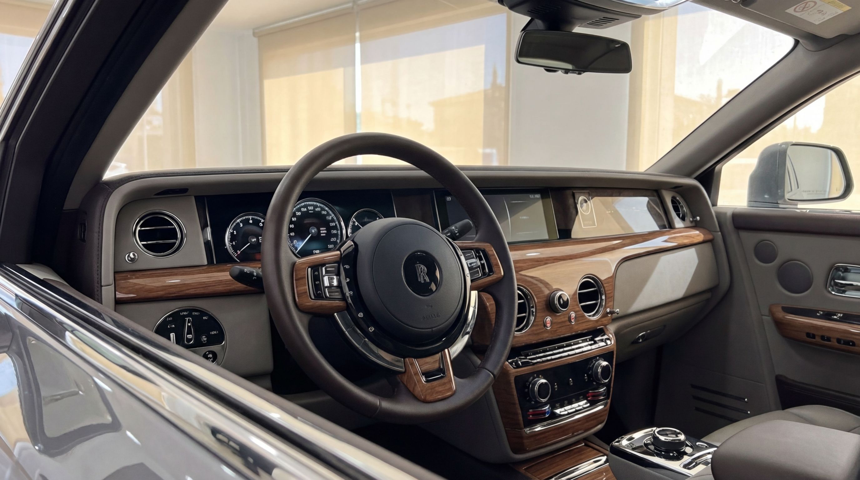 The luxurious interior of the Rolls-Royce Phantom in Mallorca, featuring a detailed view of the steering wheel, wood-trimmed dashboard, and center console.