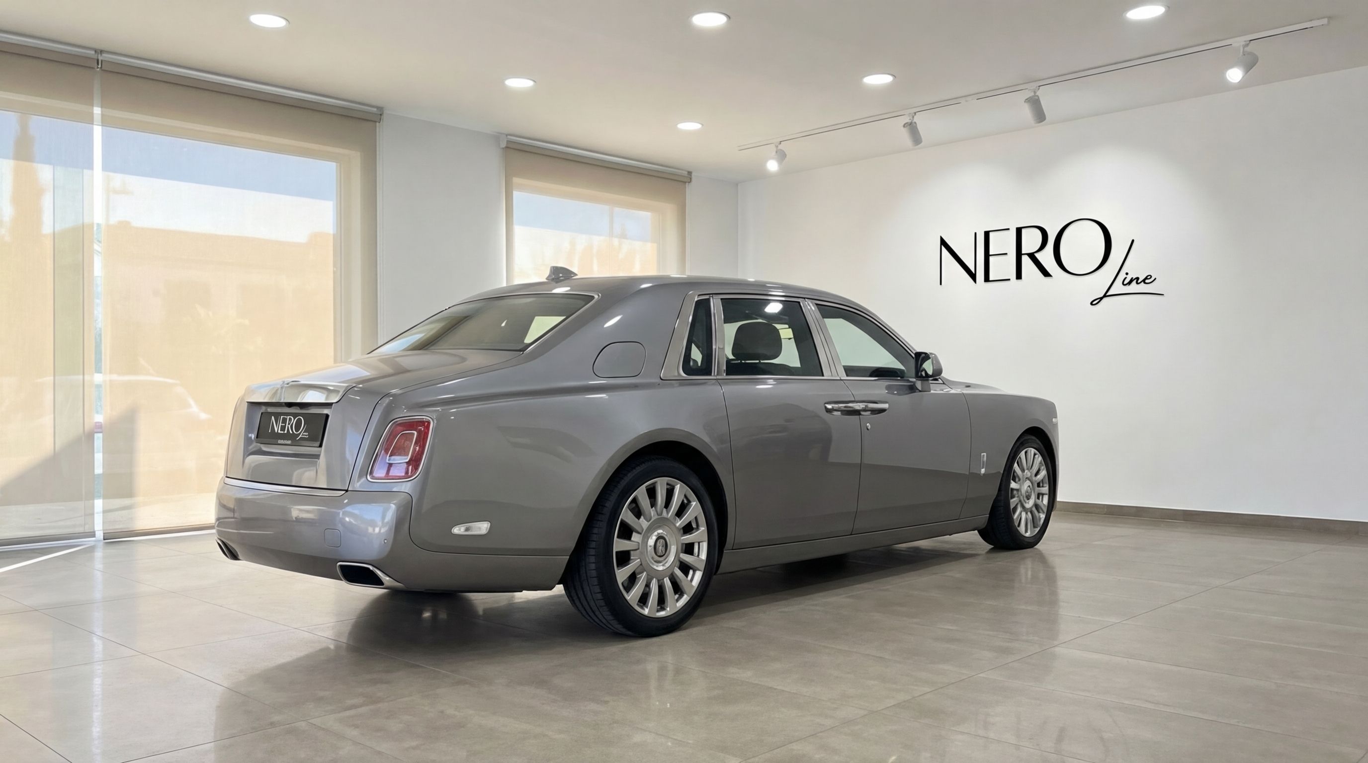 Rolls-Royce Phantom in metallic grey, captured from a rear three-quarter angle inside a showroom in Mallorca.