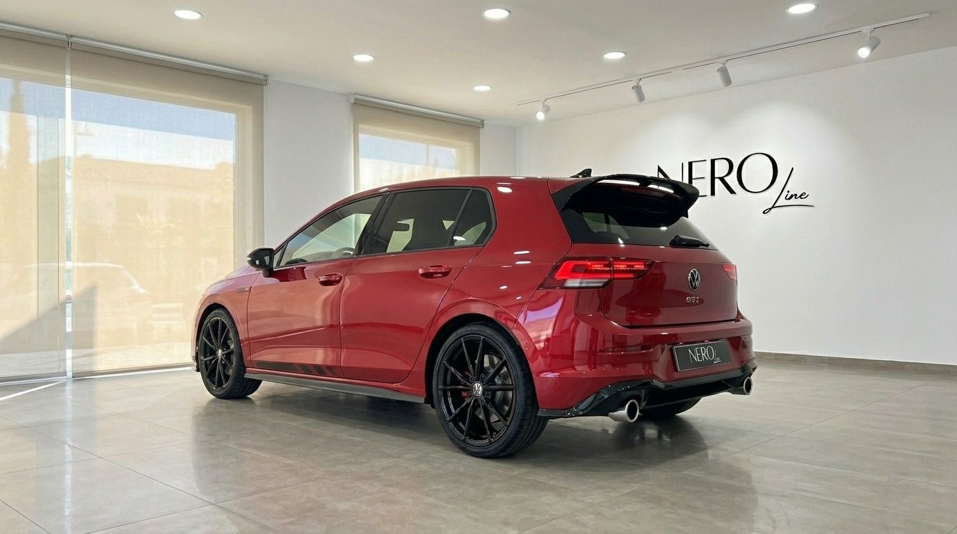 Der glänzende Kings Red Metallic 2024 Volkswagen Golf GTI Clubsport, aus der hinteren Dreiviertelansicht, geparkt in einem Showroom in Alicante.