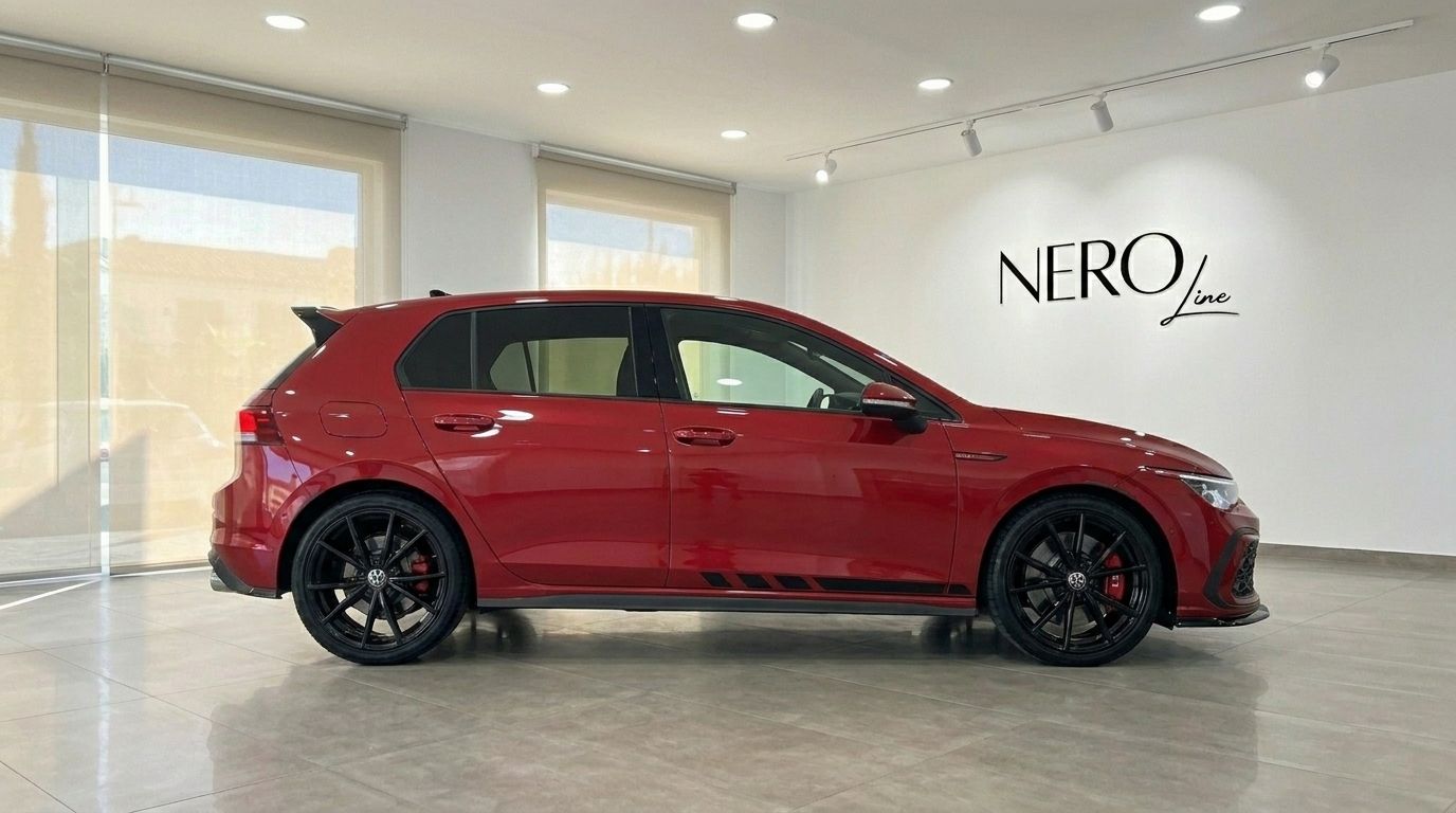 Der glänzende Kings Red Metallic 2024 Volkswagen Golf GTI Clubsport steht in einem Showroom in Alicante, in voller Seitenansicht gezeigt.
