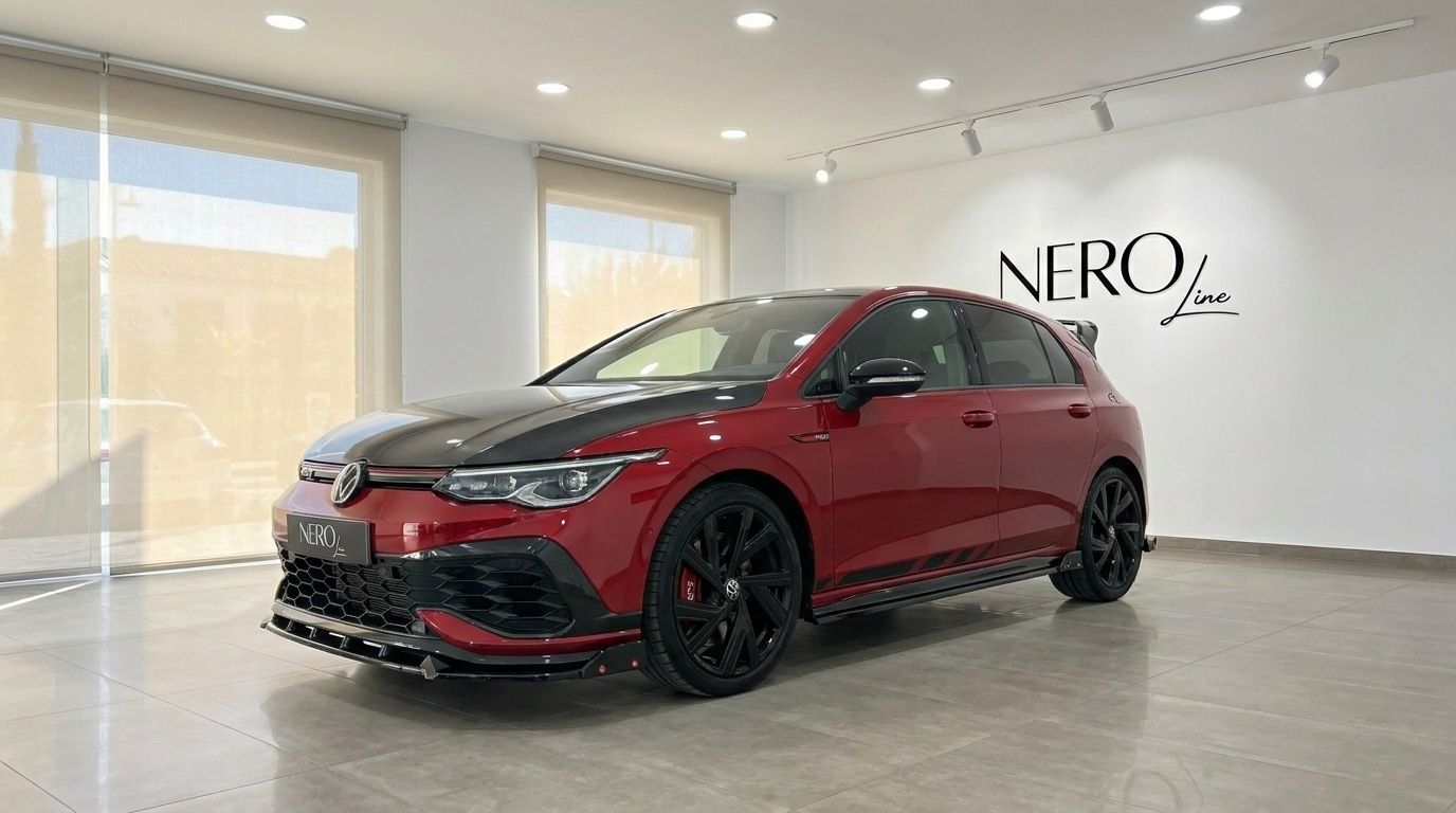 The Volkswagen Golf GTI Clubsport in gloss Kings Red Metallic is showcased from a front three-quarter angle inside a modern showroom in Alicante.