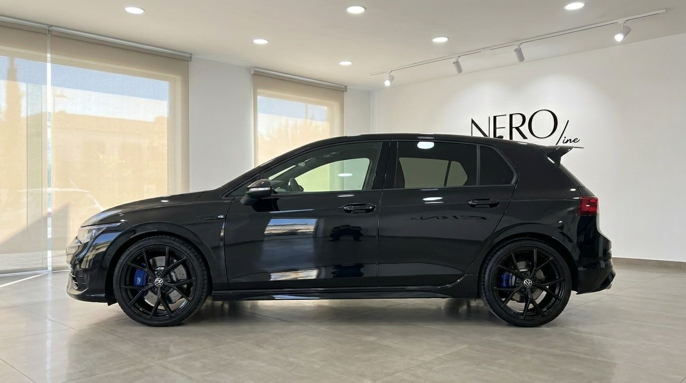 Der 2023 Volkswagen Golf R 2.0 TSI 4Motion DSG in Glänzendem Tiefschwarz wird in seinem eleganten Seitenprofil in einem Showroom in Alicante gezeigt.