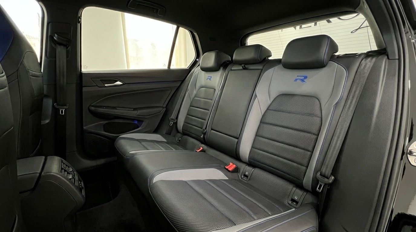 Die Rücksitze des Volkswagen Golf R 2.0 TSI 4Motion DSG, mit schwarz-grauer Polsterung und blauen R-Logos, sichtbar in Alicante.