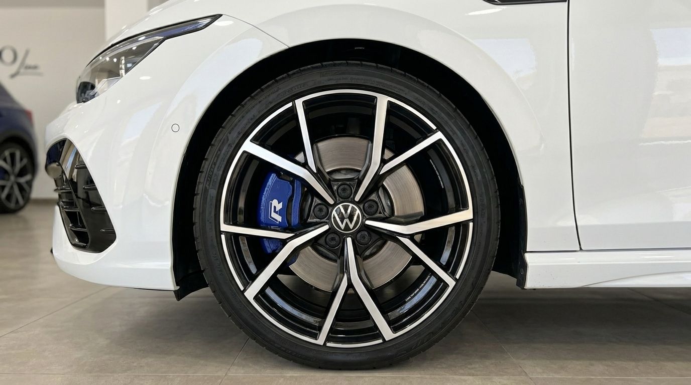 The front wheel of a white Volkswagen Golf R 2.0 TSI 4MOTION DSG, featuring blue R brake calipers, in Alicante.