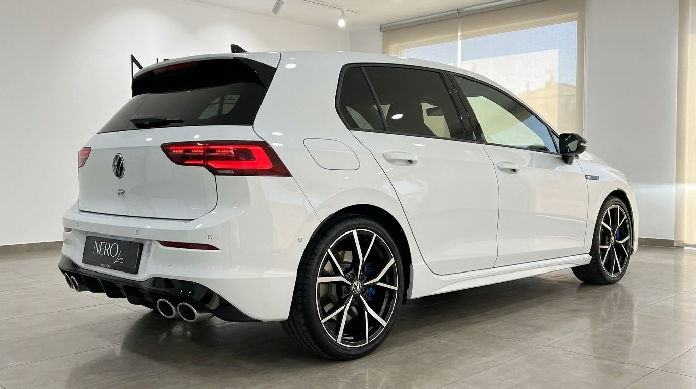 The white Volkswagen Golf R 2.0 TSI 4MOTION DSG is captured from a rear three-quarter angle, highlighting its sporty design and quad exhaust in Alicante.