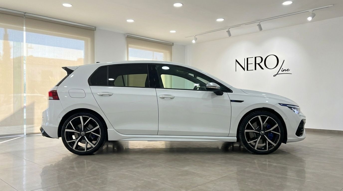 The white Volkswagen Golf R 2.0 TSI 4MOTION DSG is shown from its sleek side profile inside a modern showroom in Alicante.