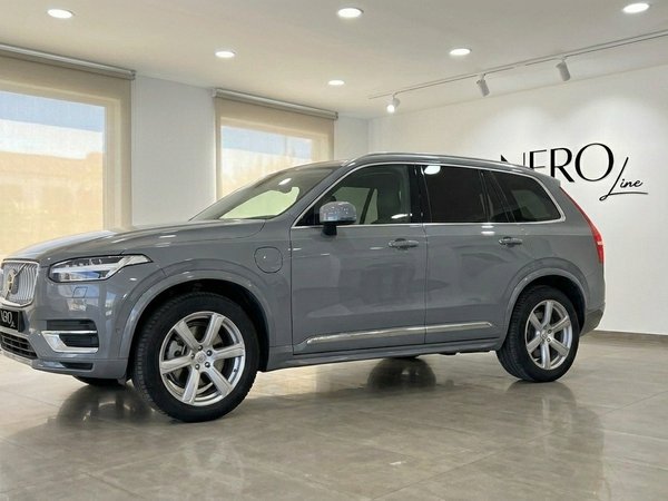 Volvo XC90 — Location de SUV Premium à Marbella Le SUV de luxe Volvo XC90 2023 gris brillant est présenté de trois quarts avant dans un showroom moderne à Marbella.