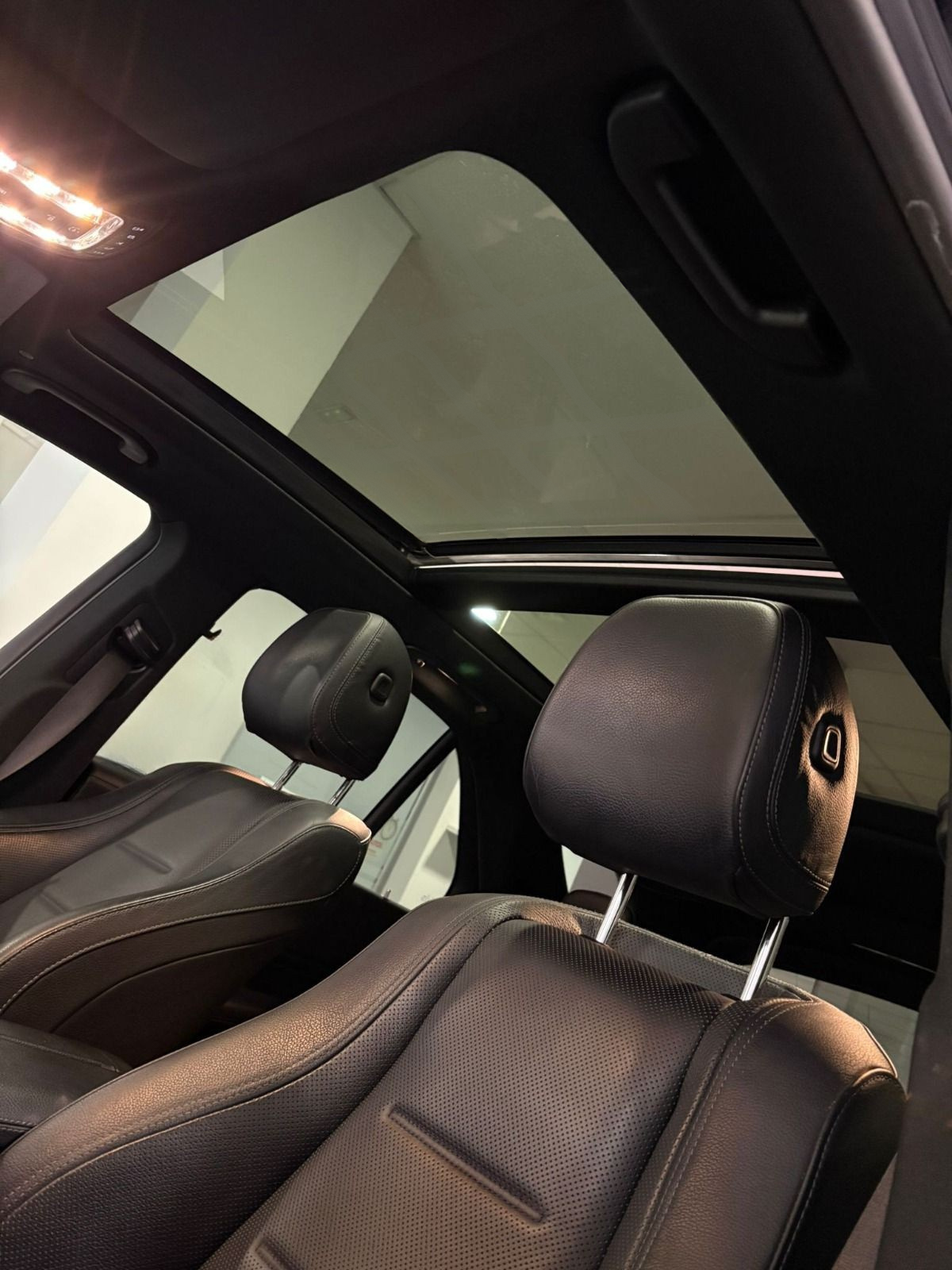 El lujoso interior del Mercedes-Benz GLE 350de en Alicante, con asientos de cuero oscuro y techo solar panorámico.