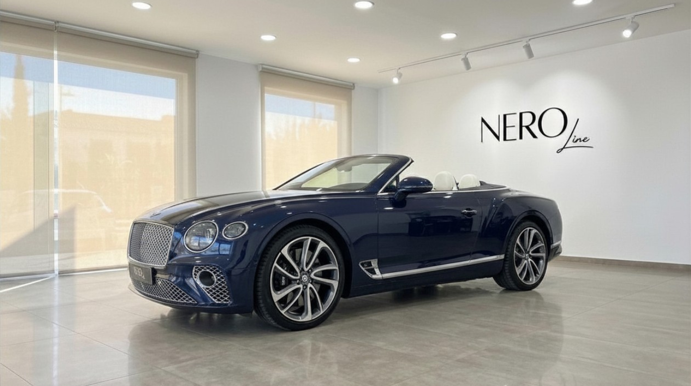 The Bentley Continental GTC convertible in Gloss Dark Sapphire Blue with its white interior is showcased in a Barcelona showroom.
