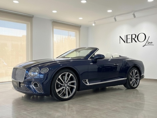 Bentley Continental GTC — Luxury Convertible in Barcelona The Bentley Continental GTC convertible in Gloss Dark Sapphire Blue with its white interior is showcased in a Barcelona showroom.