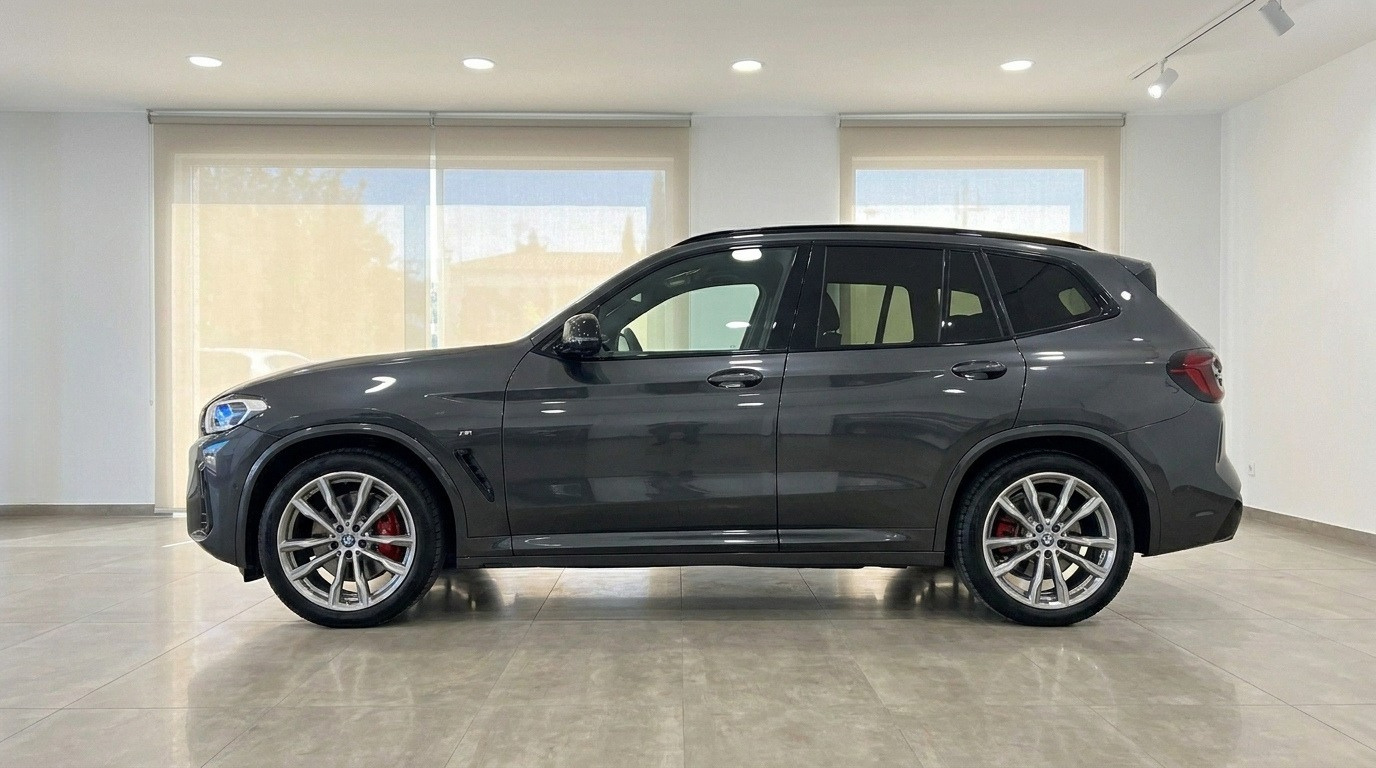 La BMW X3 M50D grigio scuro è mostrata di profilo, evidenziando il suo design elegante in uno showroom ad Alicante.